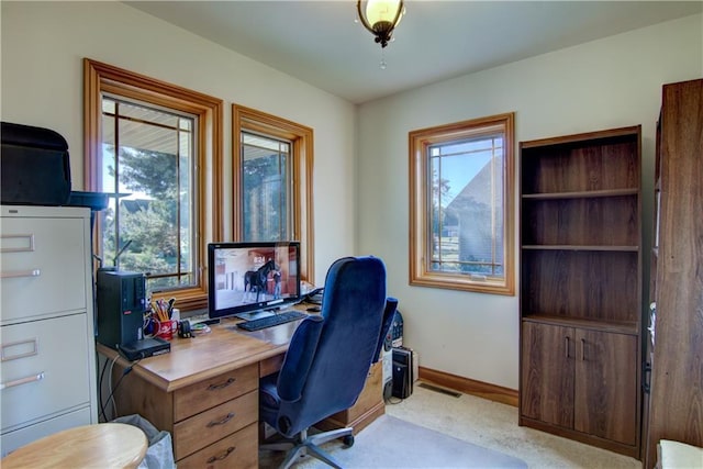 home office featuring a healthy amount of sunlight and light carpet