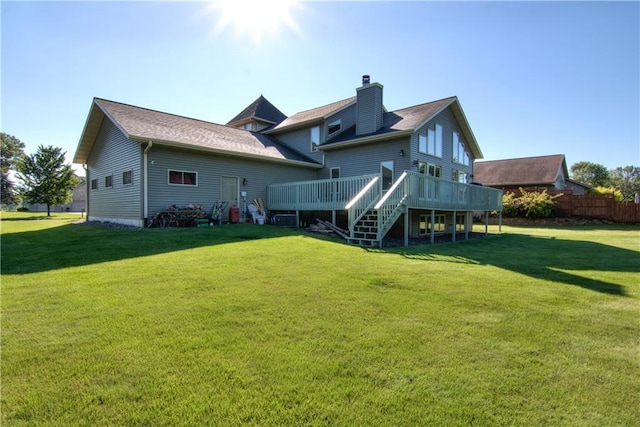 back of house featuring a lawn and a deck