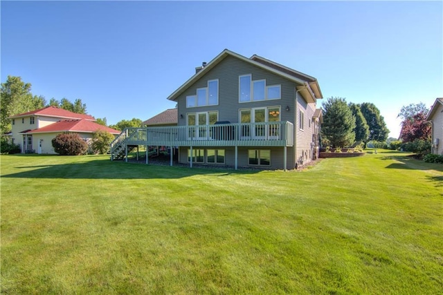 rear view of property featuring a yard and a deck