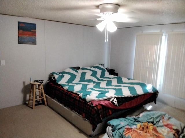 carpeted bedroom with ceiling fan and a textured ceiling