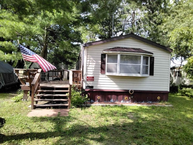 rear view of house featuring a deck and a lawn