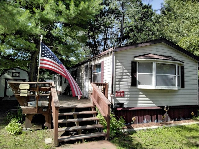 view of property exterior with a shed and a wooden deck