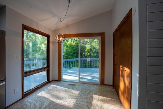 doorway to outside with a chandelier, vaulted ceiling, and a healthy amount of sunlight