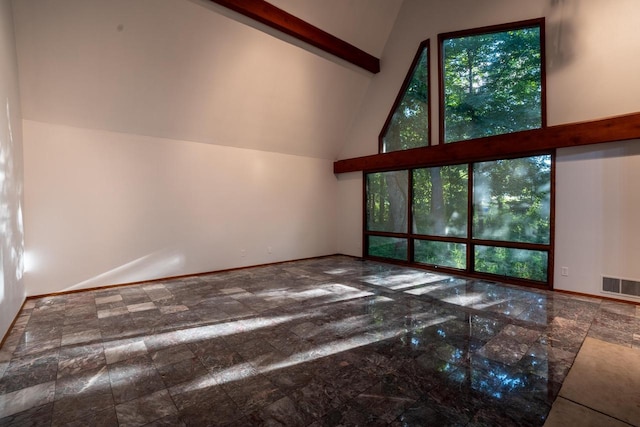 unfurnished living room featuring plenty of natural light and high vaulted ceiling