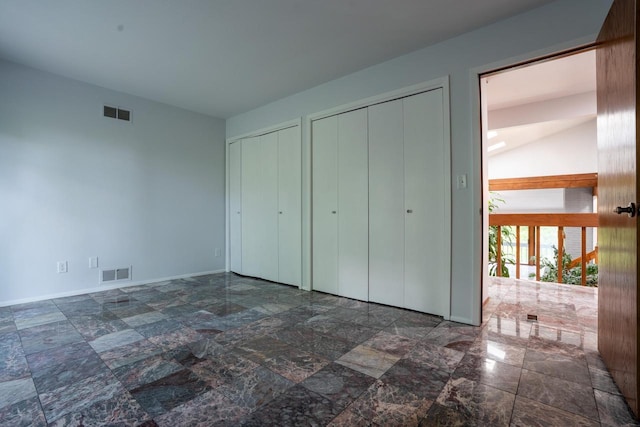 unfurnished bedroom featuring french doors and two closets