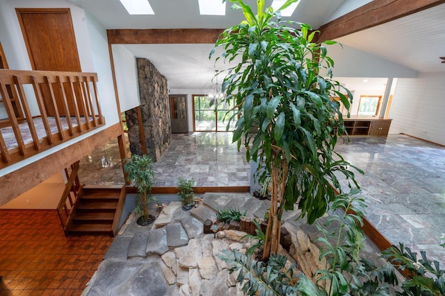 interior space featuring an inviting chandelier and lofted ceiling with skylight