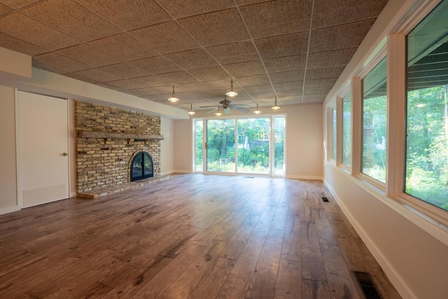 unfurnished living room with ceiling fan, wood-type flooring, and a fireplace