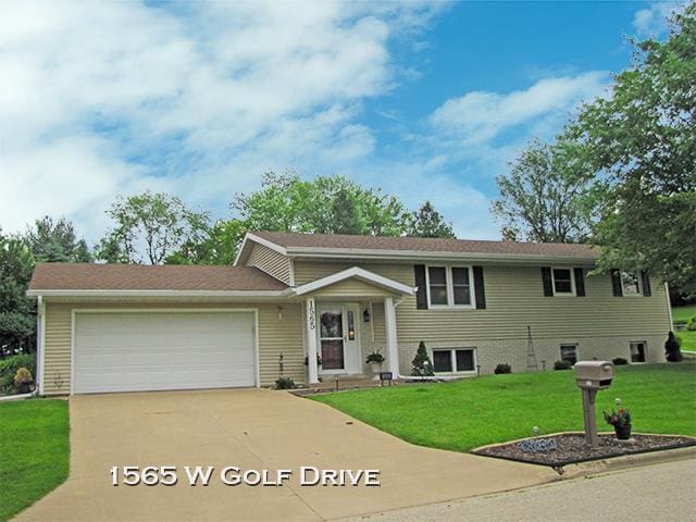 view of front of home with a garage and a front lawn