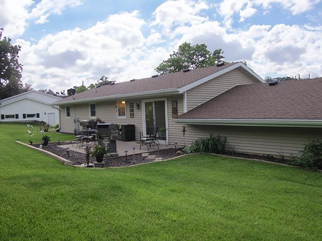 rear view of property with a lawn and a patio