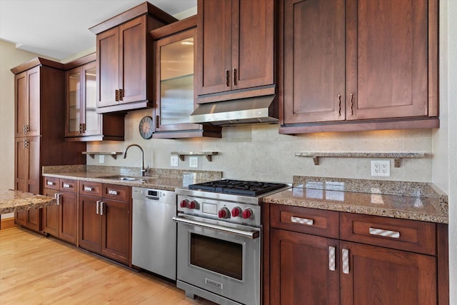 kitchen featuring light stone countertops, sink, stainless steel appliances, and light wood-type flooring