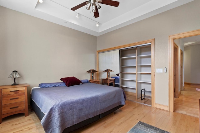 bedroom featuring ceiling fan, light hardwood / wood-style flooring, and a closet