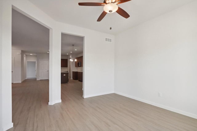 empty room with ceiling fan and light wood-type flooring