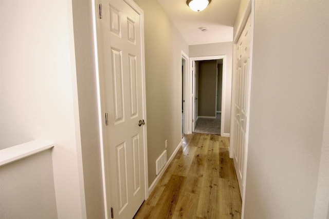 hallway with light hardwood / wood-style floors