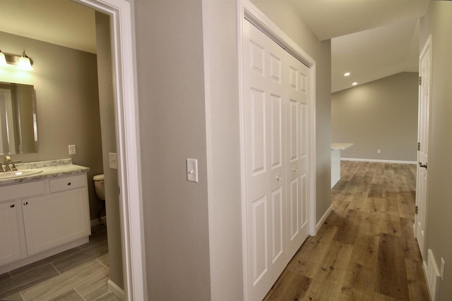 hallway with sink and light hardwood / wood-style floors