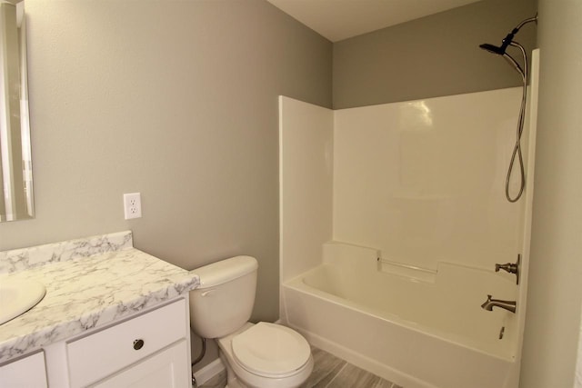 full bathroom with hardwood / wood-style floors, vanity,  shower combination, and toilet