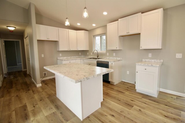 kitchen with white cabinetry, sink, a kitchen island, and pendant lighting