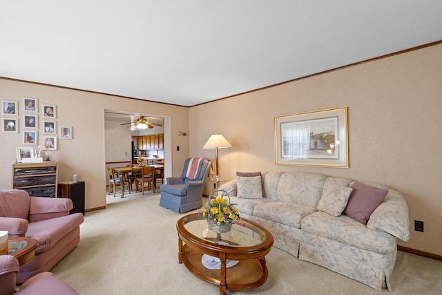 living room with ceiling fan, crown molding, and light carpet