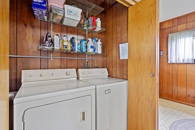 clothes washing area with wood walls and washing machine and dryer