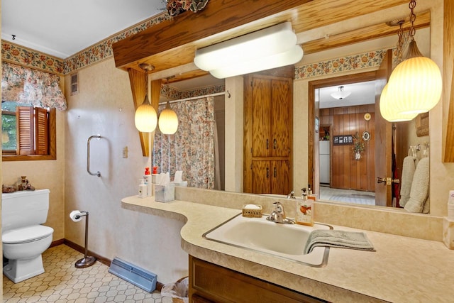 bathroom featuring a shower with curtain, wood walls, vanity, and toilet