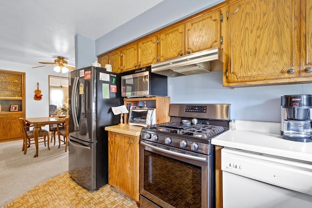 kitchen featuring ceiling fan, light carpet, and appliances with stainless steel finishes