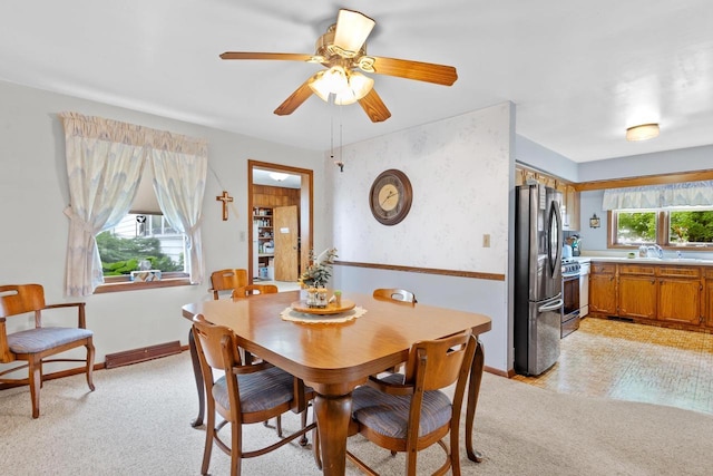 dining room featuring ceiling fan and light carpet