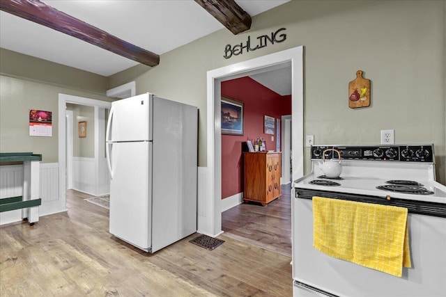 kitchen featuring beamed ceiling, white appliances, and light hardwood / wood-style flooring