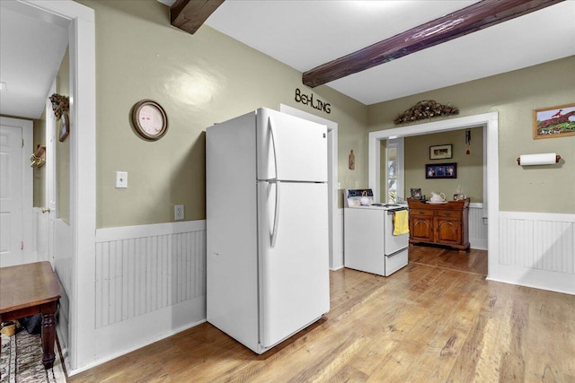 kitchen with beamed ceiling, white appliances, and light wood-type flooring