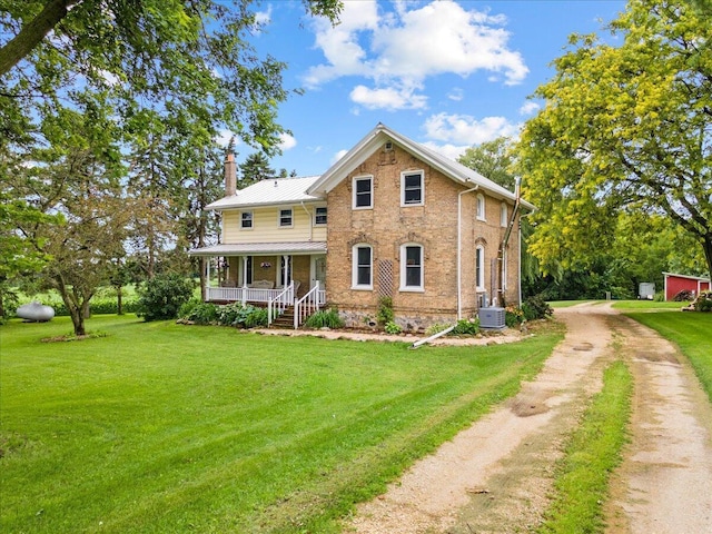 back of house featuring a yard and covered porch