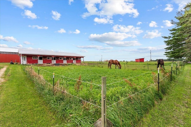 view of yard with an outbuilding and a rural view