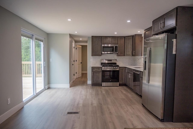 N9351 Juneau Ln, Necedah, WI 54646 - kitchen with sink, appliances with stainless steel finishes, tasteful backsplash, light hardwood / wood-style floors, and dark brown cabinetry