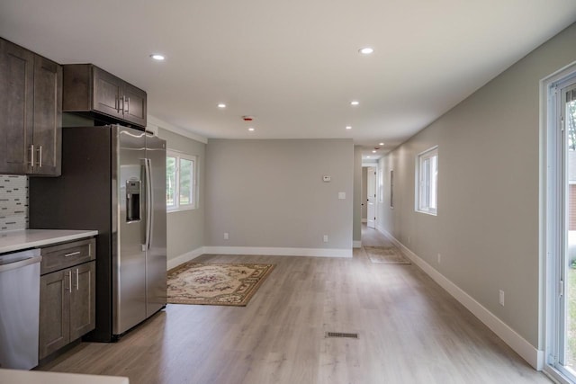 N9351 Juneau Ln, Necedah, WI 54646 - kitchen featuring decorative backsplash, light hardwood / wood-style floors, dark brown cabinetry, and appliances with stainless steel finishes