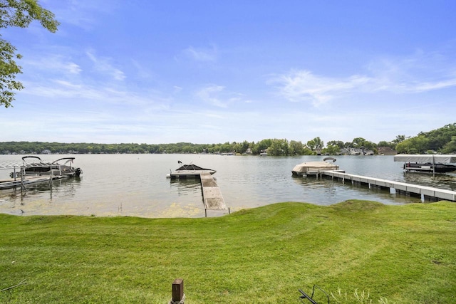 dock area featuring a lawn and a water view