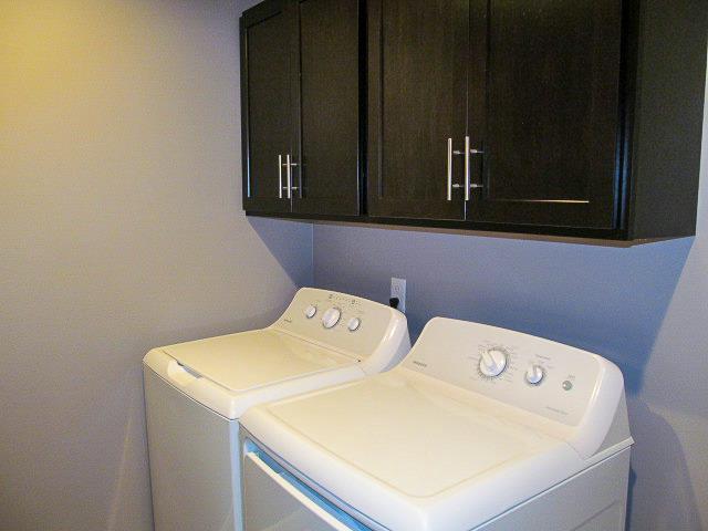 laundry area with cabinets and washer and clothes dryer