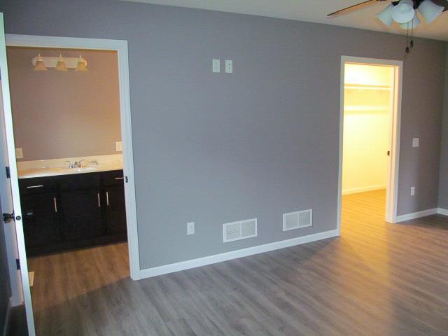 unfurnished room featuring hardwood / wood-style flooring, ceiling fan, and sink