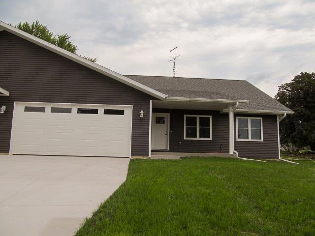 ranch-style home featuring a garage and a front lawn