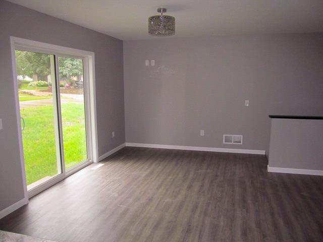 empty room featuring dark hardwood / wood-style floors and a notable chandelier