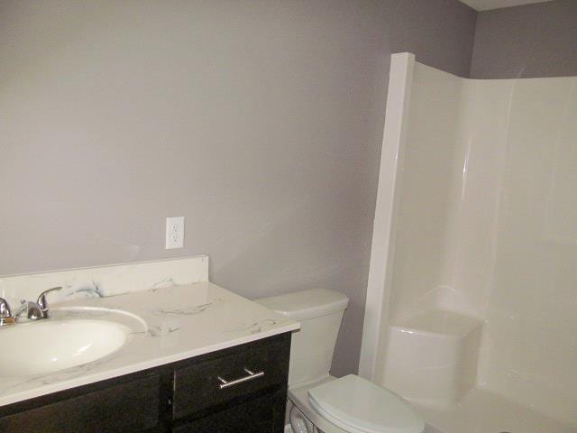 bathroom with a shower, vanity, and toilet