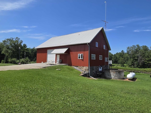 view of side of home featuring an outbuilding, a garage, and a lawn