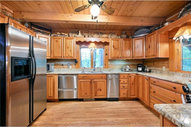 kitchen with sink, light hardwood / wood-style flooring, appliances with stainless steel finishes, beamed ceiling, and light stone counters