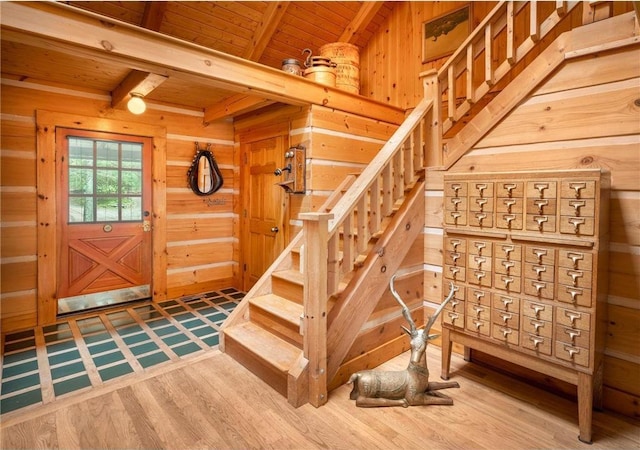 stairway featuring wood-type flooring, beam ceiling, wood ceiling, and wood walls