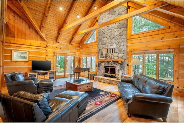 living room featuring hardwood / wood-style floors, a stone fireplace, wood ceiling, and high vaulted ceiling