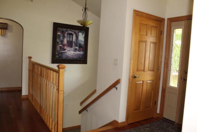 foyer entrance with dark wood-type flooring and vaulted ceiling