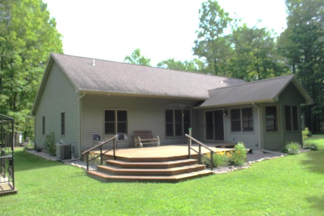 back of house featuring a deck, a yard, and central AC