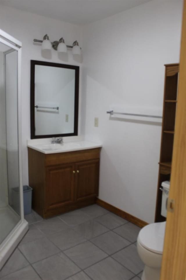 bathroom with an enclosed shower, vanity, tile patterned flooring, and toilet