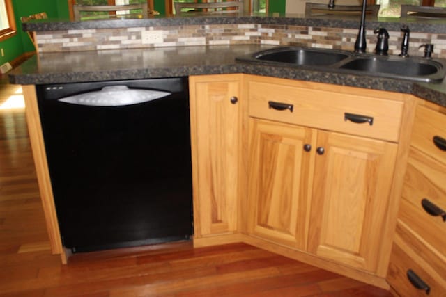 kitchen featuring decorative backsplash, dishwasher, hardwood / wood-style flooring, and sink