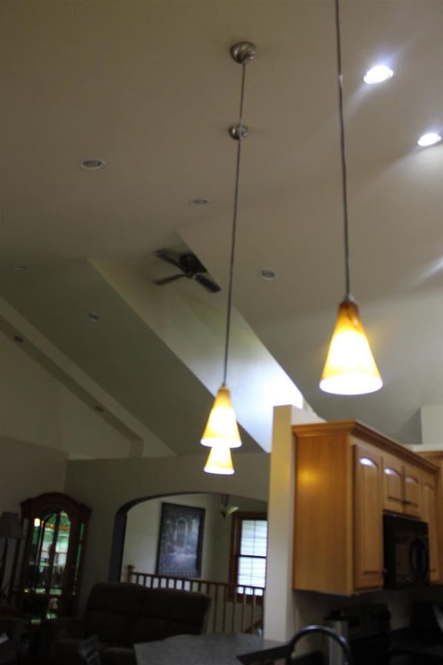 kitchen featuring ceiling fan, pendant lighting, and lofted ceiling