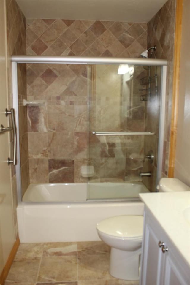 full bathroom with toilet, vanity, and shower / bath combination with glass door