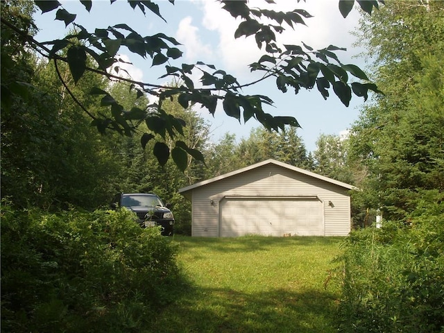 view of outbuilding featuring a garage and a yard