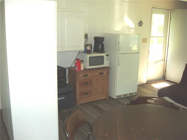 kitchen featuring white cabinets, white appliances, and dark hardwood / wood-style floors