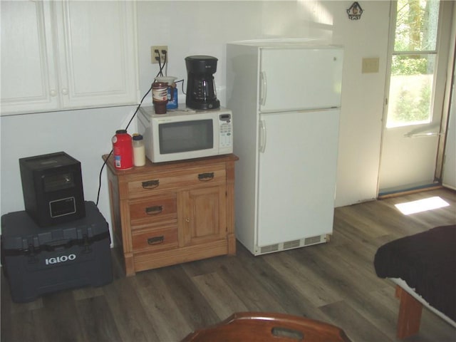 kitchen featuring white appliances and dark hardwood / wood-style floors